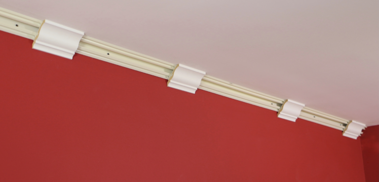 A red wall with white trim and a ceiling.