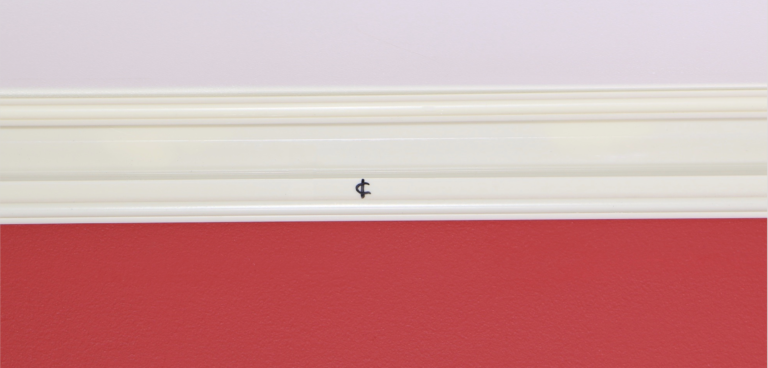 A red and white wall with a small hole in the middle.