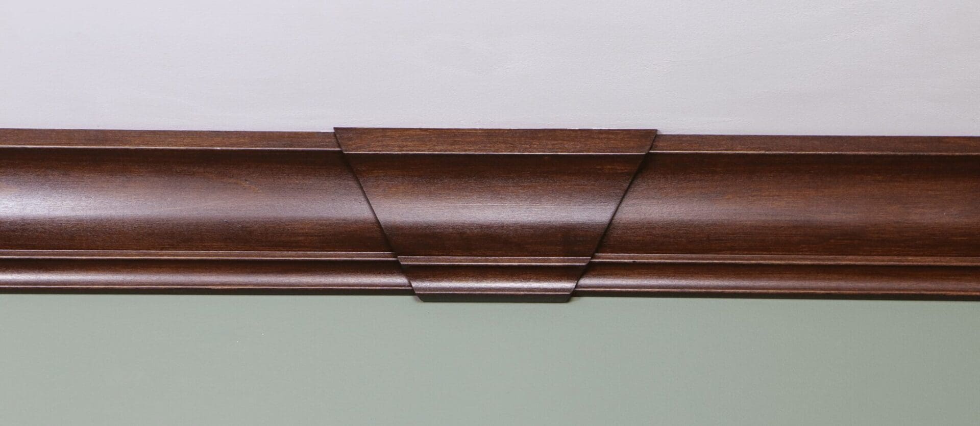 A close up of the corner of a room with wood trim.